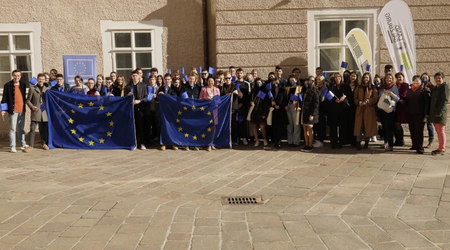 Ca 50 junge Leute vor dem Gebäude des Salzburger Landtags. Sie halten EU-Flaggen. Das Foto ist im Rahmen des Projekts EU-Talks entstanden.